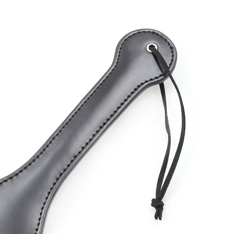 Sort Spanking Fun SLUT Paddle i holdbart PVC med snor til håndled, 32x6 cm, let og elegant til leg og nydelse